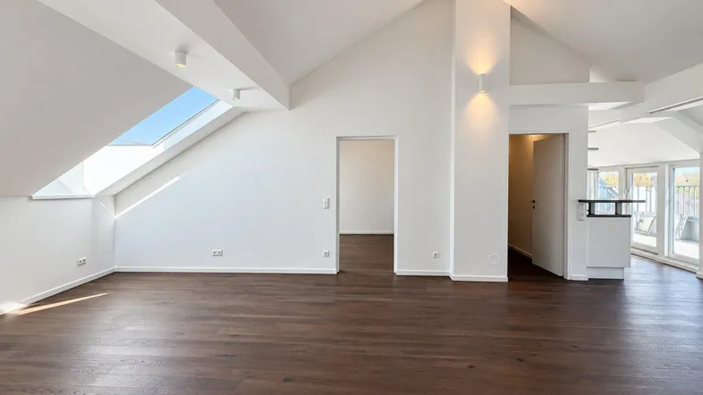 Geräumiges und helles Dachgeschoss-Wohnzimmer mit Holzboden und Zugang zur Terrasse.