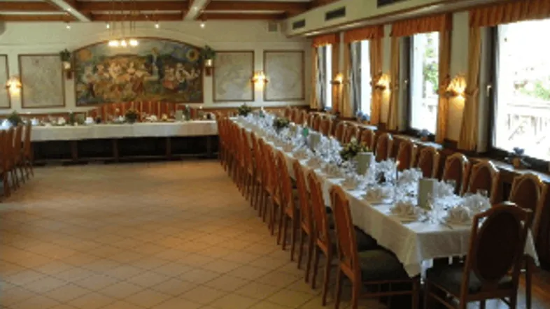 Weitläufiger Speisesaal mit Reihen von Tischen, großen Fenstern und traditioneller Einrichtung.