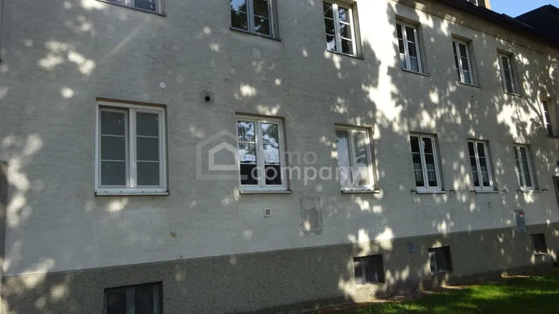Fassade eines Altbaus mit mehreren Fenstern, einem Kellergeschoss und Dachgauben unter einem Schrägdach.