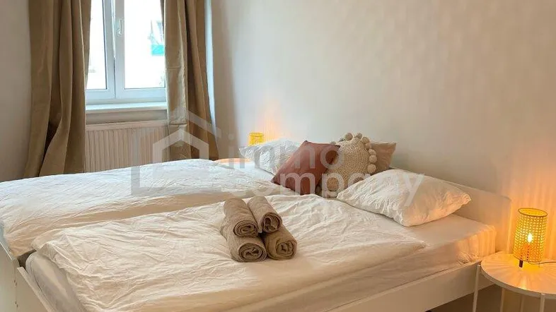 Helles Schlafzimmer mit zwei Einzelbetten, Holzboden und natürlichem Lichteinfall.