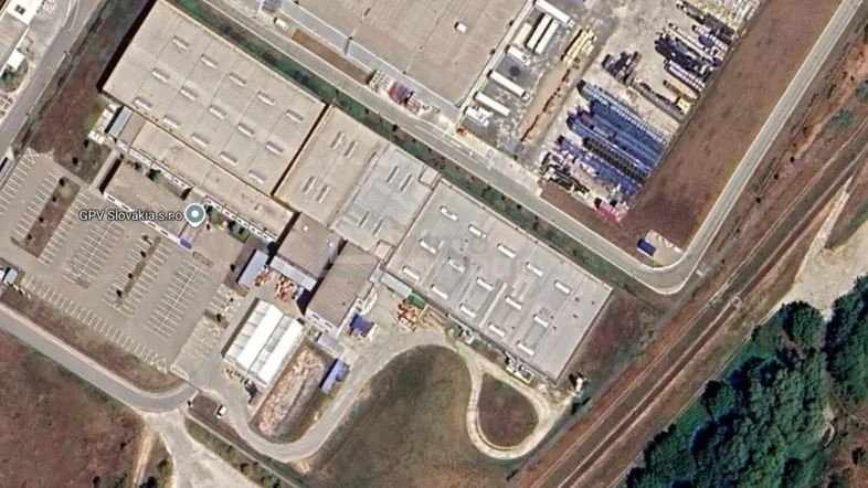 Luftaufnahme eines großen Industriekomplexes mit mehreren Hallen und Parkplätzen.