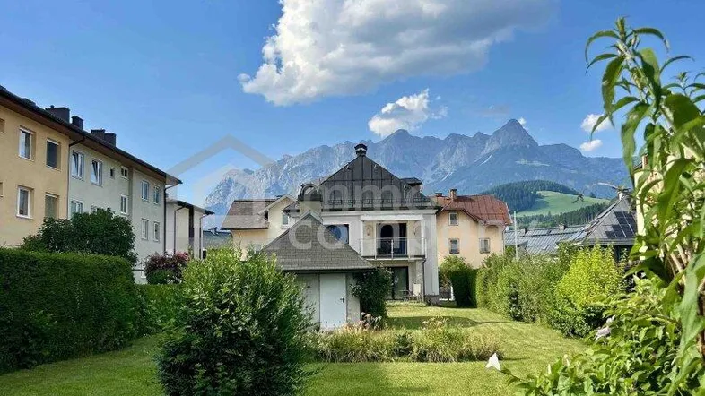 Großer Garten mit gepflegtem Rasen und Blick auf die umliegende Berglandschaft.