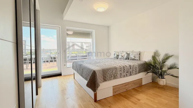 Lichtdurchflutetes Schlafzimmer mit Holzboden und direktem Zugang zur Terrasse.