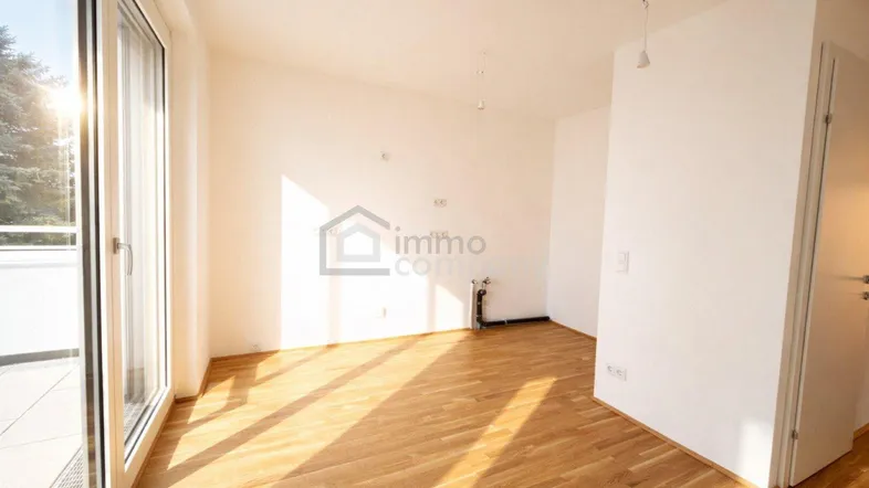 Heller, leerer Raum mit großen Schiebetüren und Holzboden, ideal für individuelle Gestaltung und viel Tageslicht.