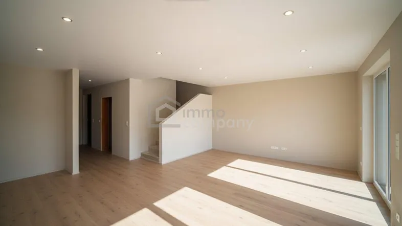 Heller, leerer Raum mit Holzfußboden und Treppenaufgang, ideal für einen offenen Wohnbereich.