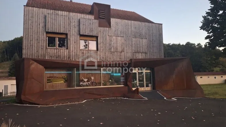 Moderne Architektur mit einer Fassade aus Holz und rostigem Metall sowie einem barrierefreien Eingangsbereich.