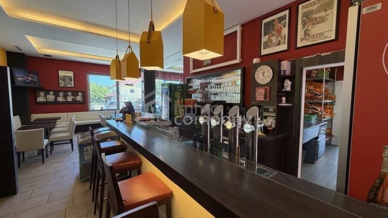 Geräumiger Barbereich mit langer Theke, Barhockern und Sitzgelegenheiten, ideal für Gastronomiebetriebe.