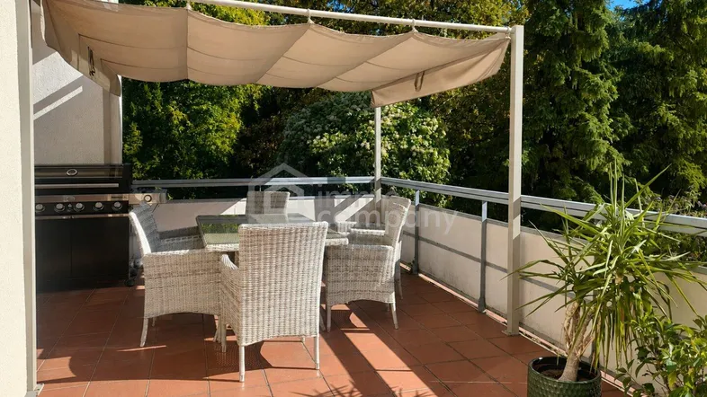Geräumige Terrasse mit Essbereich, Sonnenschutz und Blick ins Grüne, ideal für Mahlzeiten im Freien.