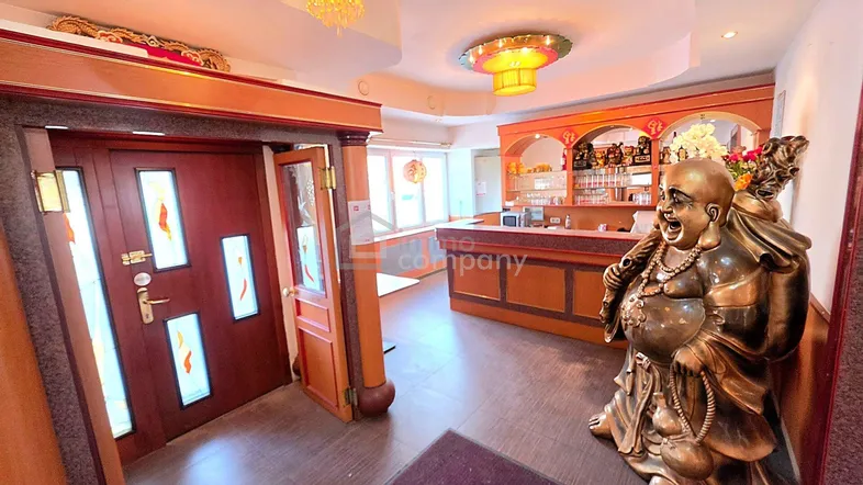 Empfangsbereich mit traditioneller Dekoration, Holzelementen und einer großen Buddha-Statue.