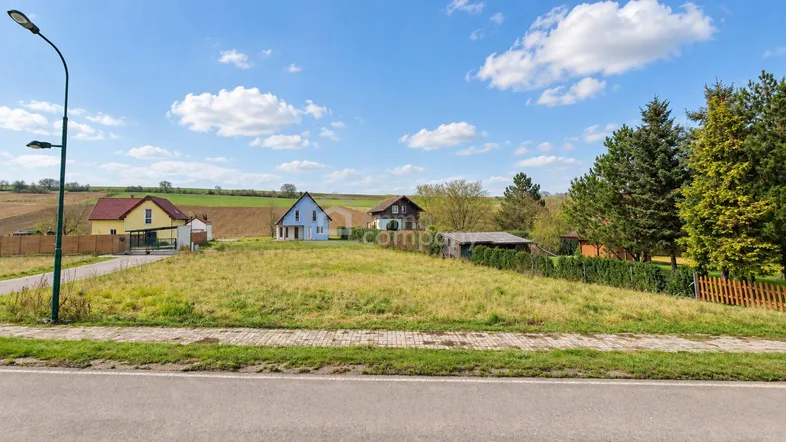 Weitläufiges Grundstück mit Blick auf die umliegende Landschaft und weitere Häuser unter blauem Himmel.