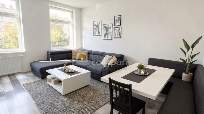 Heller Wohn- und Essbereich mit modernem Sofa, Esstisch und großen Fenstern für viel Tageslicht.