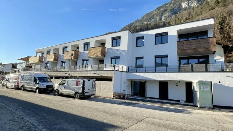 Modernes Mehrfamilienhaus mit Balkonen und Bergblick in sonniger Lage.