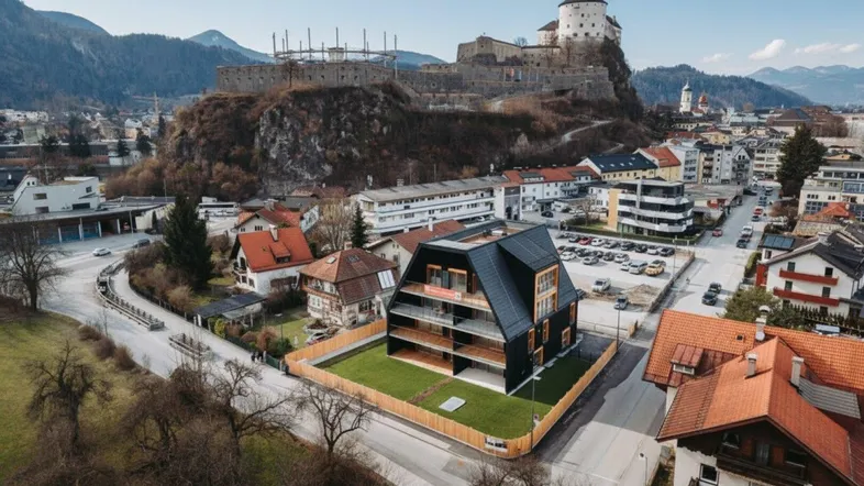 Moderne Architektur mit markantem Dach und Balkonen, umgeben von einer städtischen Landschaft mit Burg im Hintergrund.