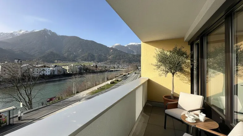 Geräumiger Balkon mit Sitzgelegenheiten, Blick auf den Fluss und die umliegenden Berge.