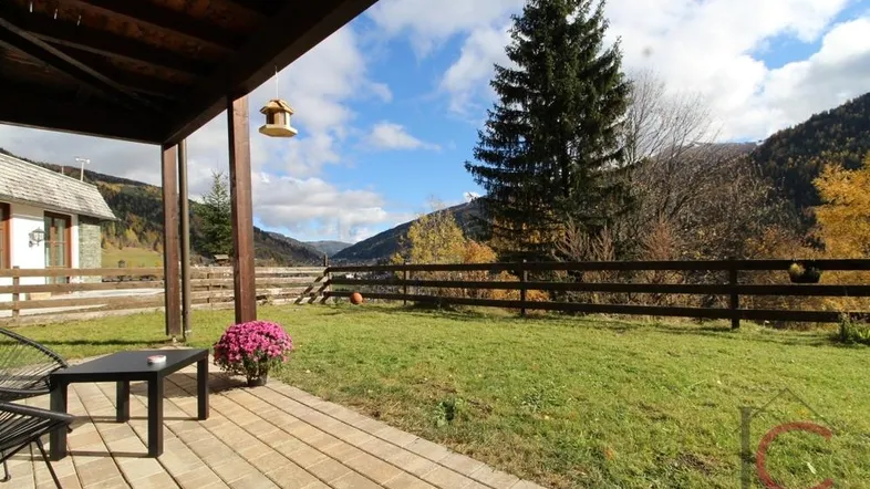 Überdachte Terrasse mit Sitzgelegenheiten und weitem Blick auf die umliegende Berglandschaft.