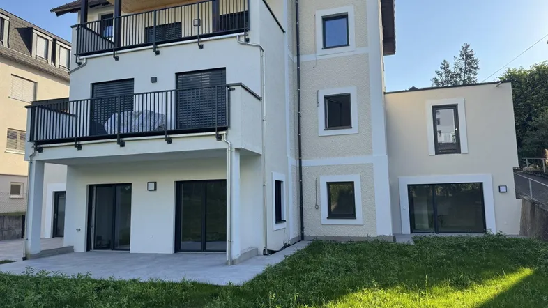 Neubau mit mehreren Balkonen, einer Terrasse und angrenzendem Gartenbereich in sonniger Lage.