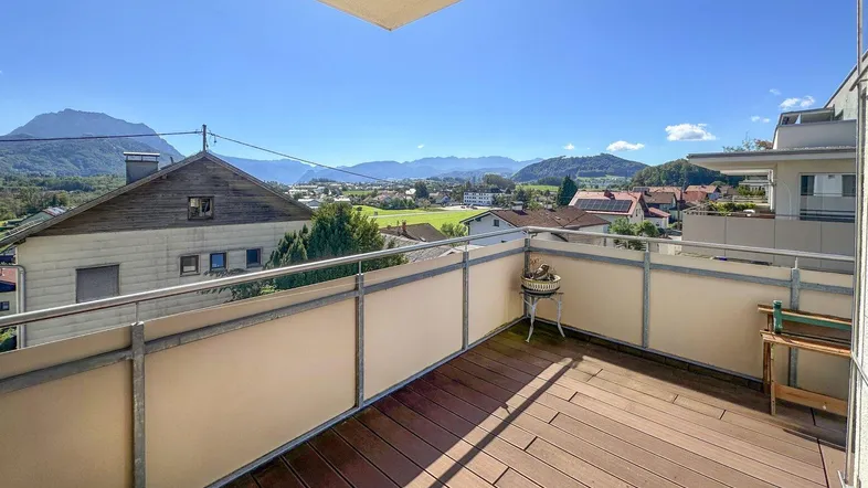 Geräumiger Balkon mit Holzboden und weitem Blick auf die umliegende Berglandschaft.