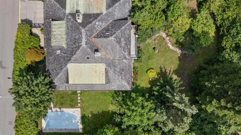 Luftaufnahme des Anwesens mit großem Garten, altem Baumbestand und einem Pool.