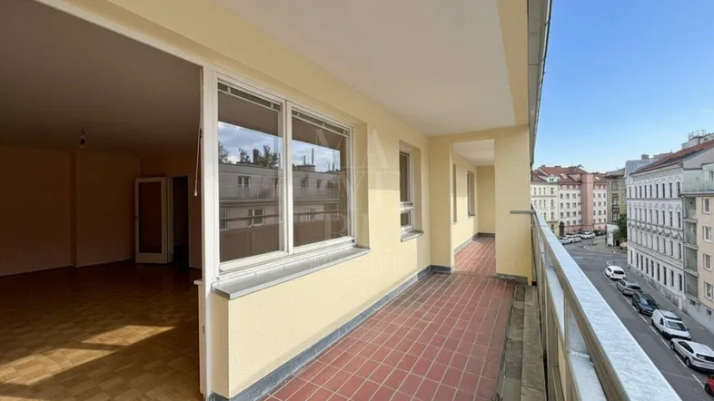 Lange Loggia mit Terrakottafliesen und Blick auf die Stadt, zugänglich vom Wohnbereich.