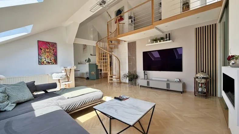 Helles Wohnzimmer mit modernem Sofa, Kamin und eleganter Wendeltreppe, die zu einem offenen Bereich führt.