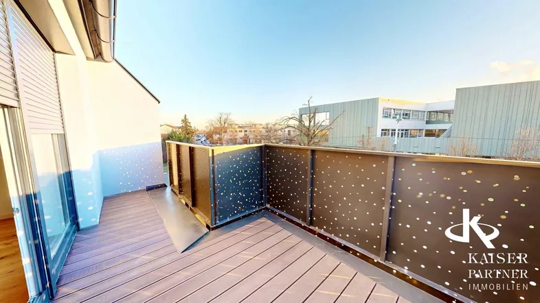 Geräumige Terrasse mit modernem Geländer und Blick auf die Umgebung unter blauem Himmel.