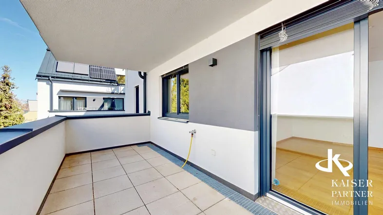 Heller Balkon mit Fliesenboden und Blick auf die Umgebung, ideal für entspannte Stunden im Freien.