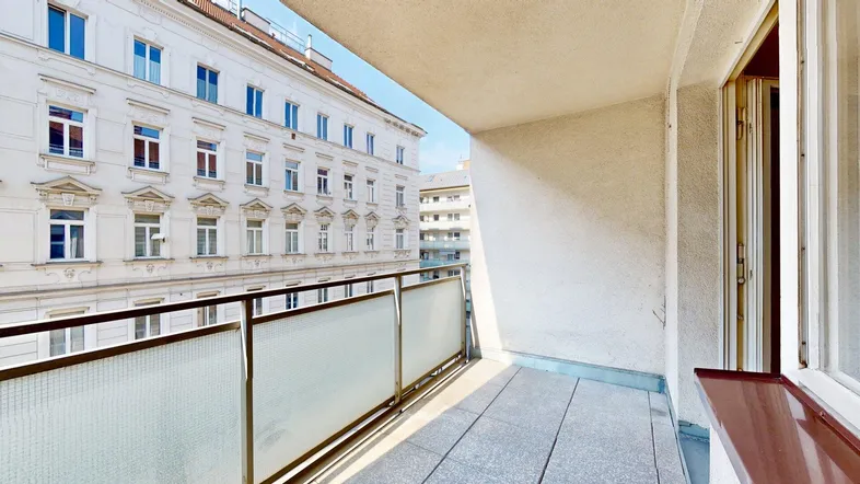 Geräumiger Balkon mit Blick auf die historische Fassade eines gegenüberliegenden Gebäudes.