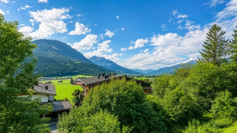 Malerische Berglandschaft mit traditionellen Häusern und üppiger grüner Natur unter blauem Himmel.