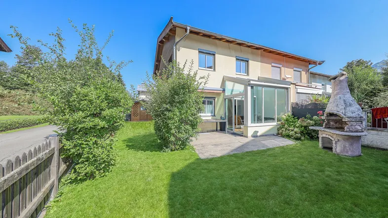 Großzügiger Gartenbereich mit Rasenfläche, Terrasse, Wintergarten und gemauertem Grill.