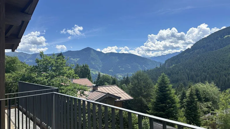 Balkon mit Bergblick und grüner Umgebung, ideal zum Entspannen im Freien.