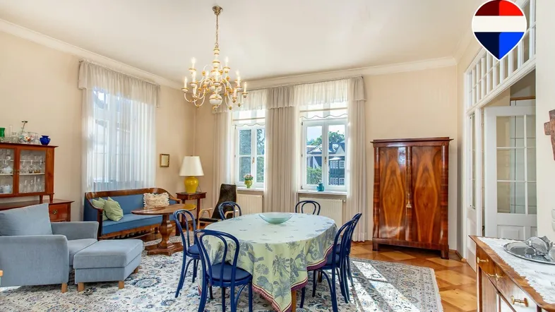 Geräumiger Wohn- und Essbereich mit klassischem Interieur, Parkettboden und Kronleuchter.