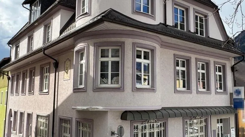 Historisches Gebäude mit markanter Architektur und runden Erkern in einer städtischen Umgebung.