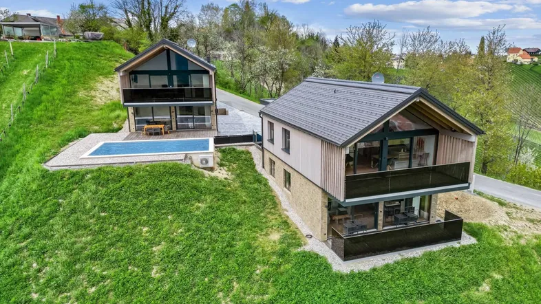 Zwei moderne Häuser mit Pool und weitem Blick über die hügelige Landschaft und Weinberge.