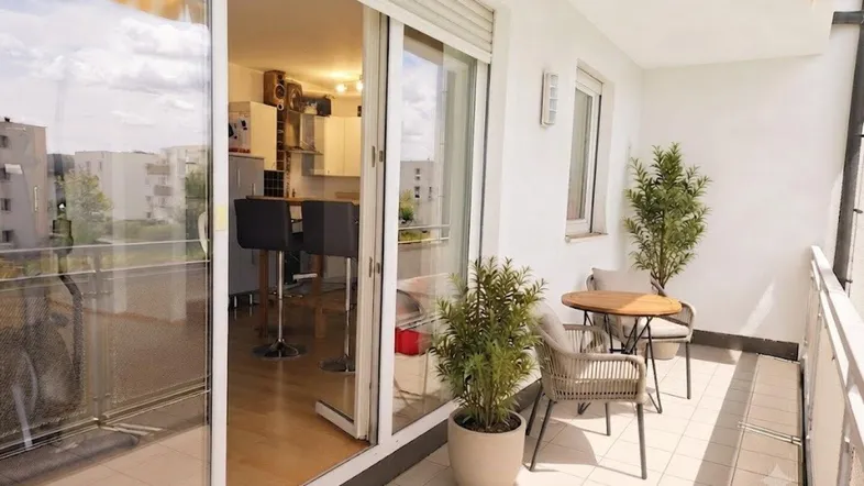 Heller Balkon mit Fliesenboden und Sitzgelegenheiten, mit Blick in die offene Küche.