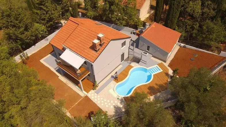 Luftaufnahme des Anwesens mit Pool, Terrasse und umgebender Natur.