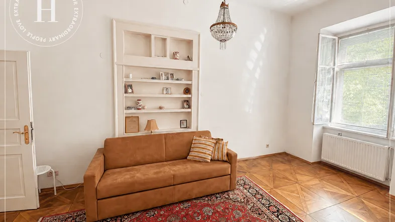 Helles Wohnzimmer mit elegantem Parkettboden, eingebauten Regalen und einem klassischen Kronleuchter.