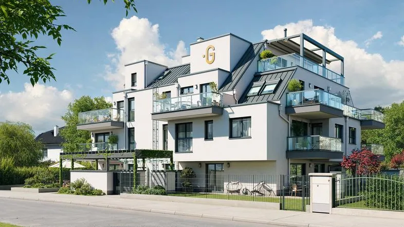 Moderne Wohnanlage mit mehreren Balkonen und Dachterrassen unter blauem Himmel und umgeben von Grün.