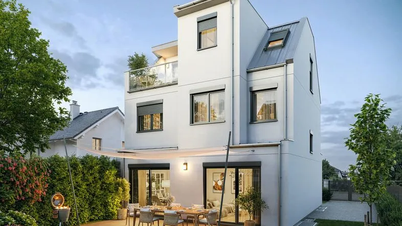 Moderne weiße Hausfassade mit großer möblierter Terrasse, Grillbereich und gepflegtem Garten.
