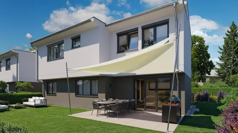 Modernes Reihenhaus mit großem Garten, möblierter Terrasse und Sonnensegel unter blauem Himmel.