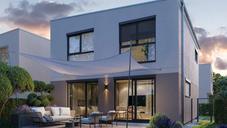 Moderne Doppelhaushälfte mit möblierter Terrasse, Garten und Sonnensegel am Abend.
