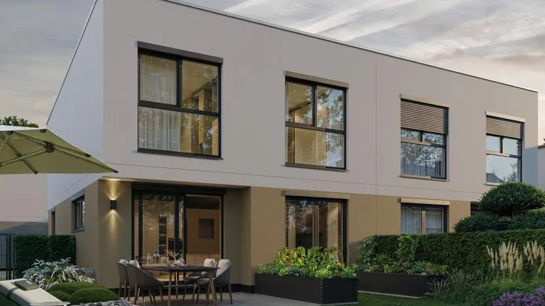 Moderne Hausfassade mit großer Terrasse, Garten und Sonnenliege, ideal für entspannte Stunden im Freien.