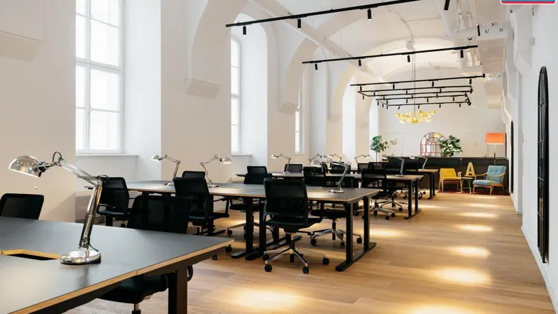 Großes, offenes Büro mit vielen Arbeitsplätzen, hohen Gewölbedecken und großen Fenstern für viel Tageslicht.