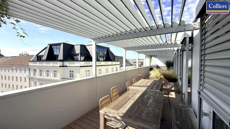 Geräumige Dachterrasse mit Holzmöbeln und Pergola, bietet einen weiten Blick über die Stadt.