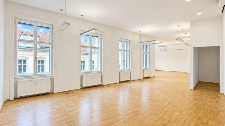 Geräumiges, helles Büro mit Parkettboden und großen Fenstern, ideal für moderne Arbeitsumgebungen.