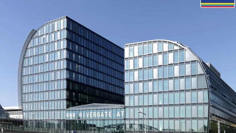 Moderne Bürogebäude mit geschwungenen Glasfassaden und klarem Himmel, repräsentiert zeitgenössische Architektur.