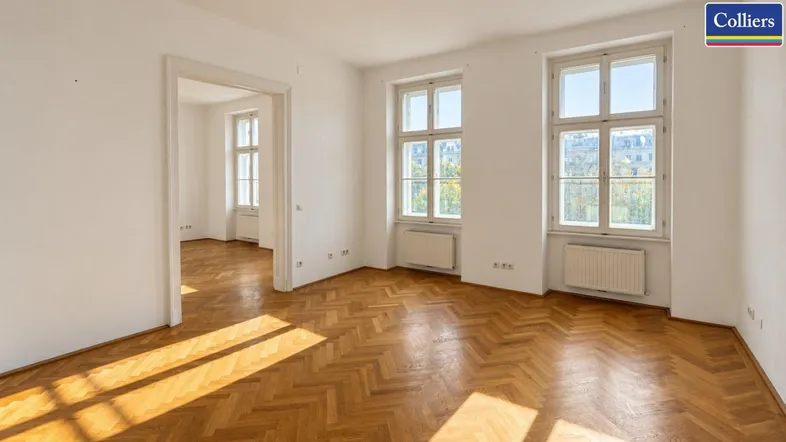 Helles Zimmer mit Fischgrätparkettboden und großen Fenstern, das viel Tageslicht hereinlässt.