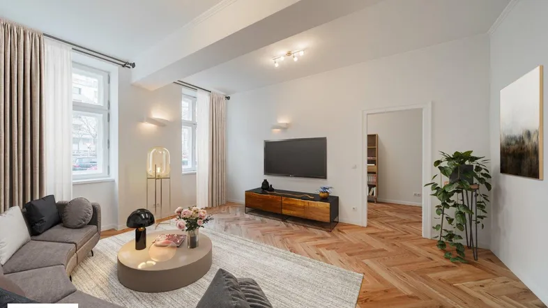 Helles Wohnzimmer mit Fischgrätparkett, modernem Sofa und Blick auf die Straße.