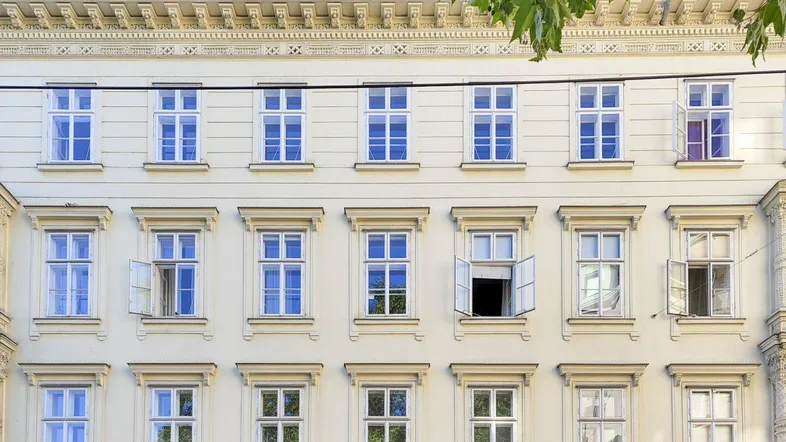 Klassische Fassade eines Wiener Altbaus mit vielen Fenstern und dekorativen Elementen.