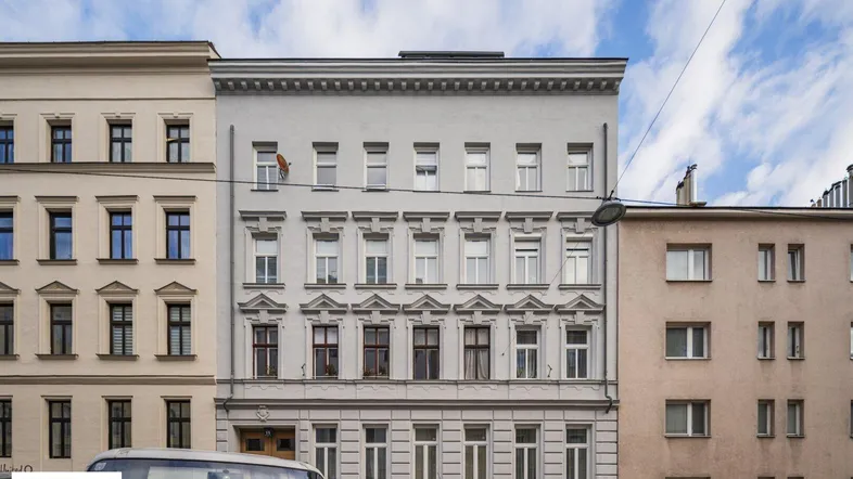 Klassische Fassade eines Altbaus in der Stadt mit vielen Fenstern und traditionellen Details.