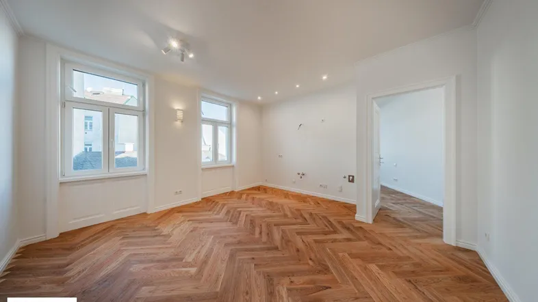 Helles, frisch renoviertes Zimmer mit Fischgrätparkett und hohen Fenstern, bereit zum Einzug.
